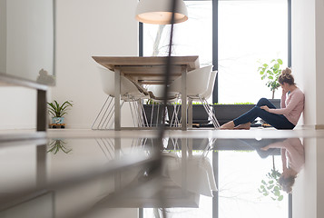 Image showing young woman using mobile phone on the floor