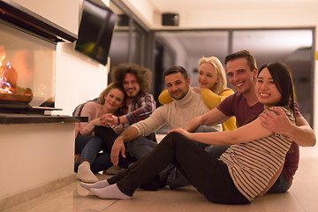 Image showing multiethnic couples sitting in front of fireplace