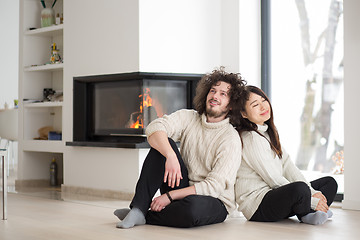 Image showing happy multiethnic couple  in front of fireplace