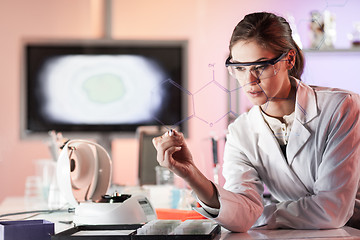 Image showing Portrait of a confident female researcher in life science laboratory writing structural chemical formula on a glass board.