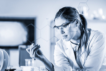 Image showing Portrait of a confident female researcher in life science laboratory writing structural chemical formula on a glass board.