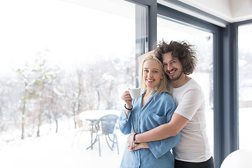 Image showing young couple enjoying morning coffee by the window