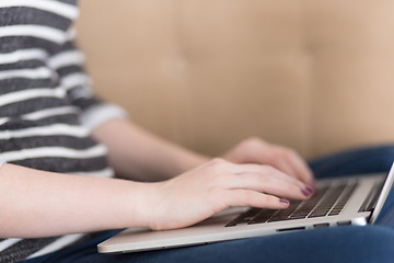 Image showing young woman on sofa at home websurfing