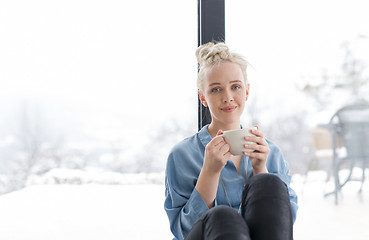 Image showing woman drinking coffee and using laptop at home