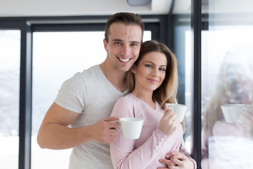 Image showing young couple enjoying morning coffee by the window