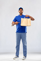 Image showing happy indian delivery man with food in paper bag