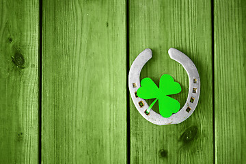 Image showing horseshoe with shamrock on green wood boards