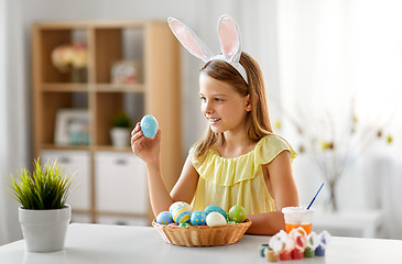 Image showing happy girl with colored easter eggs at home