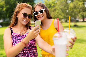 Image showing teenage girls with smartphone and shakes in park