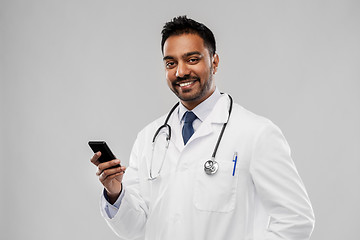 Image showing smiling indian male doctor with smartphone