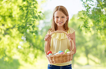 Image showing happy girl with colored eggs in wicker basket