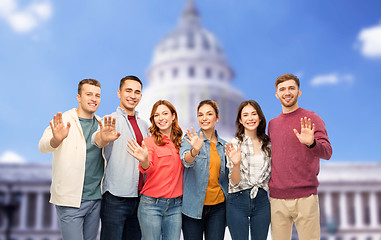 Image showing group of smiling friends over capitol building