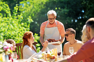 Image showing family having dinner or barbecue at summer garden