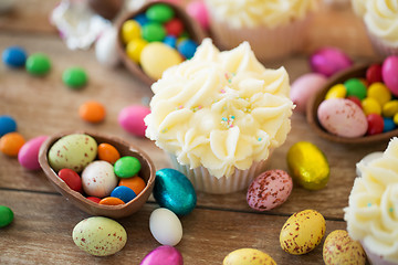 Image showing cupcake with chocolate eggs and candies on table