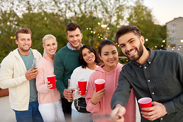 Image showing friends with drinks taking selfie at rooftop party