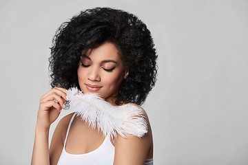 Image showing Beautiful mixed race woman holding white ostrich feather