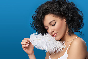 Image showing Beautiful mixed race woman holding white ostrich feather