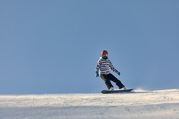 Image showing Female snowboarder in sun flare