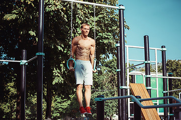 Image showing Athlete doing exercises at stadium at park