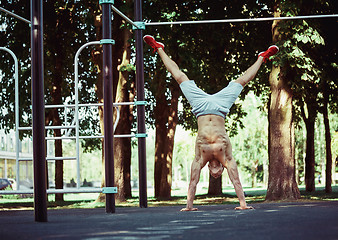 Image showing Athlete doing exercises at stadium at park