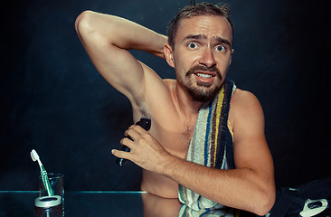 Image showing Photo of handsome man shaving his armpit