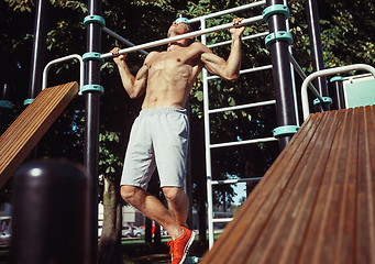 Image showing Athlete doing exercises at stadium at park