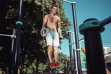 Image showing Athlete doing exercises at stadium at park