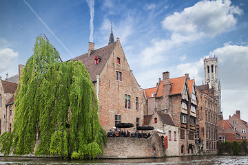 Image showing Bruges, Belgium - May 17, 2012: The famous Belfry tower, old houses and a street cafe on the water channel in Bruges on a sunny day