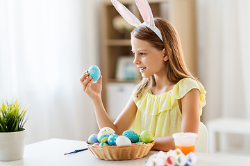 Image showing happy girl with colored easter eggs at home