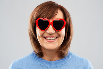 Image showing smiling senior woman in heart-shaped sunglasses