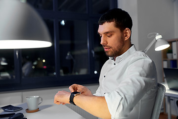 Image showing businessman using smart watch at nigh office