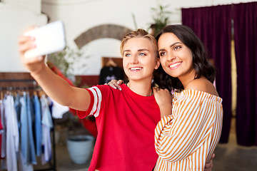 Image showing female friends taking selfie at clothing store