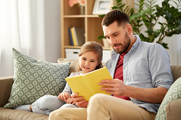 Image showing happy father and daughter reading book at home