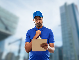 Image showing indian delivery man with clipboard in blue