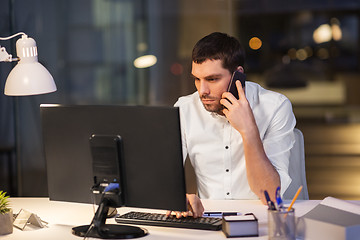 Image showing businessman calling on smartphone at night office