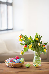 Image showing colored easter eggs in basket and flowers at home