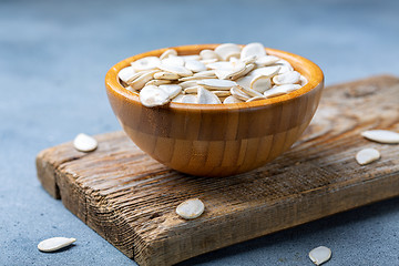 Image showing Unpeeled pumpkin seeds in a wooden bowl.