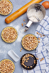 Image showing Preparation of baskets of dough for onion mini pies.