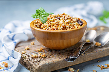 Image showing Granola with baked apple in a wooden bowl.