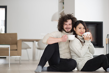 Image showing happy multiethnic couple  in front of fireplace