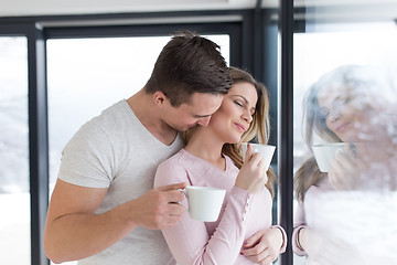 Image showing young couple enjoying morning coffee by the window