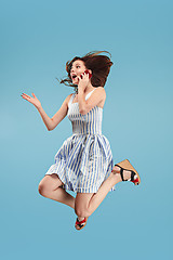 Image showing Full length of pretty young woman with mobile phone while jumping