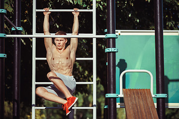 Image showing Athlete doing exercises at stadium at park