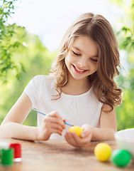 Image showing happy smiling girl coloring easter eggs