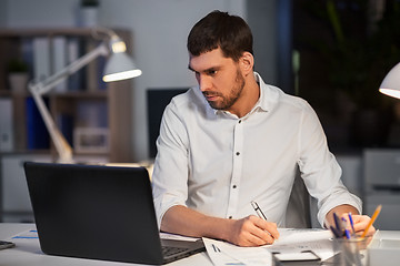 Image showing businessman with laptop working at night office