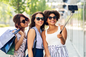 Image showing women with shopping bags taking selfie outdoors