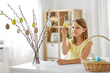 Image showing girl decorating willow by easter eggs at home