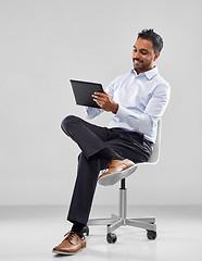 Image showing indian businessman with tablet pc on office chair