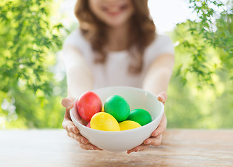 Image showing close up of girl with bowl of colored easter eggs