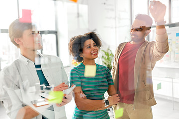 Image showing happy creative team at office glass board